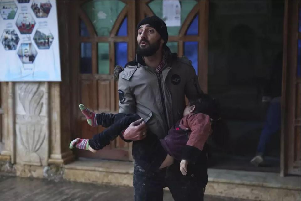 Σύριος κρατά στα χέρια του σώμα ενός μικρού κοριτσιού που ανασύρθηκε νεκρό μέσα από τα ερείπια της οικίας του