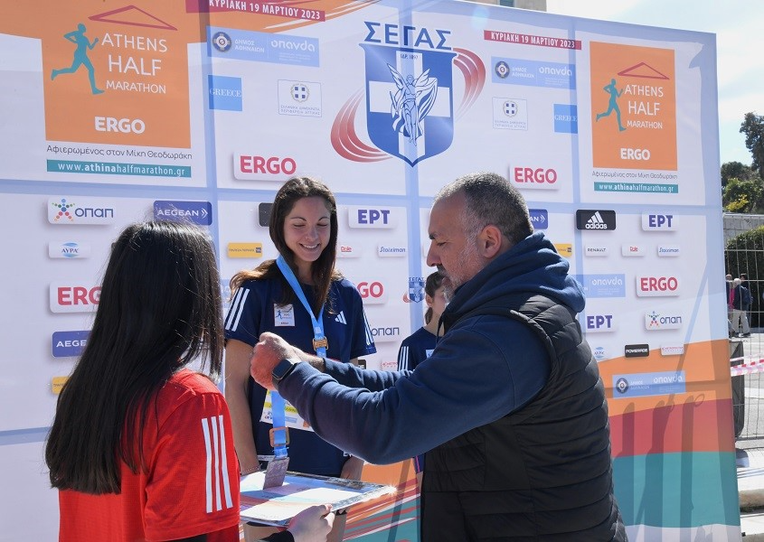 Ο Head of Sponsorships του ΟΠΑΠ, Θανάσης Μπασδέκης, βραβεύει τη 2η νικήτρια του Ημιμαραθωνίου Βασιλική Κωνσταντινοπούλου