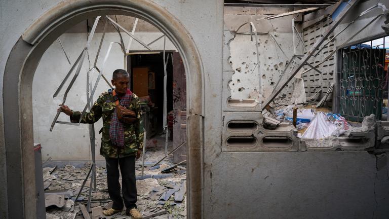 Ταϊλανδός πολίτης στην είσοδο του μισοκατεστραμμένου από βομβαρδισμούς σπιτιού του 