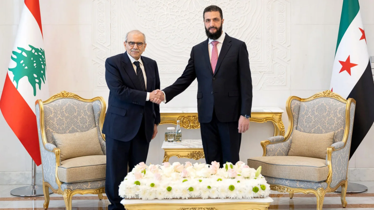 Syrian President Ahmed al-Sharaa (R) shakes hands with Lebanese Prime Minister Nawaf Salam at the People's Palace in Damascus