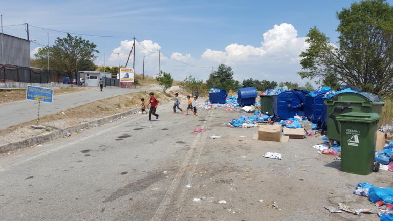 Προσφυγόπουλα παίζουν δίπλα σε «βουνό» σκουπιδιών, στη δομή φιλοξενίας στο Δερβένι