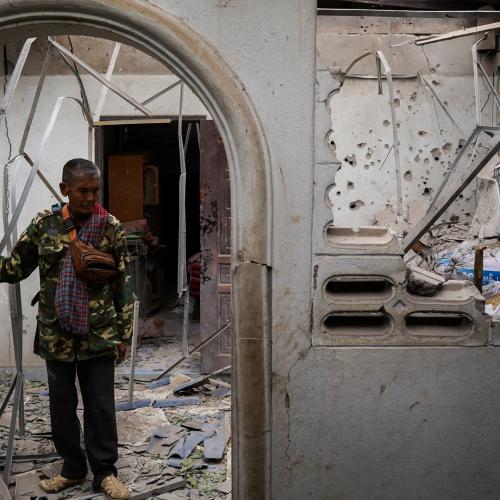 Ταϊλανδός πολίτης στην είσοδο του μισοκατεστραμμένου από βομβαρδισμούς σπιτιού του 
